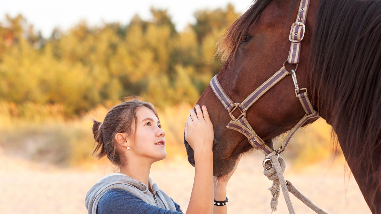 A young owner gazing at her horse.