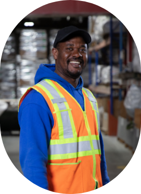 An operational employee in a Sollio Agriculture warehouse happy to be at work.