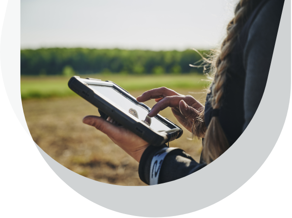 Un producteur agricole qui navigue sur sa tablette électronique dans son champ.