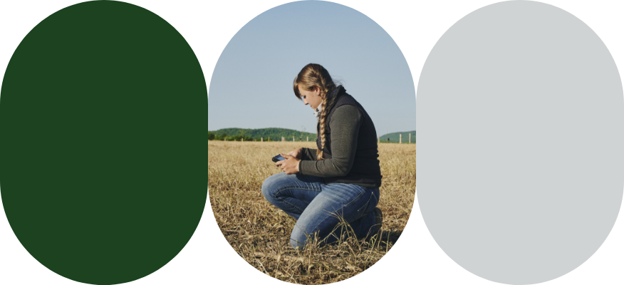 An agri-advisor crouched in a field enters data into the AgConnexion platform on her iPad.