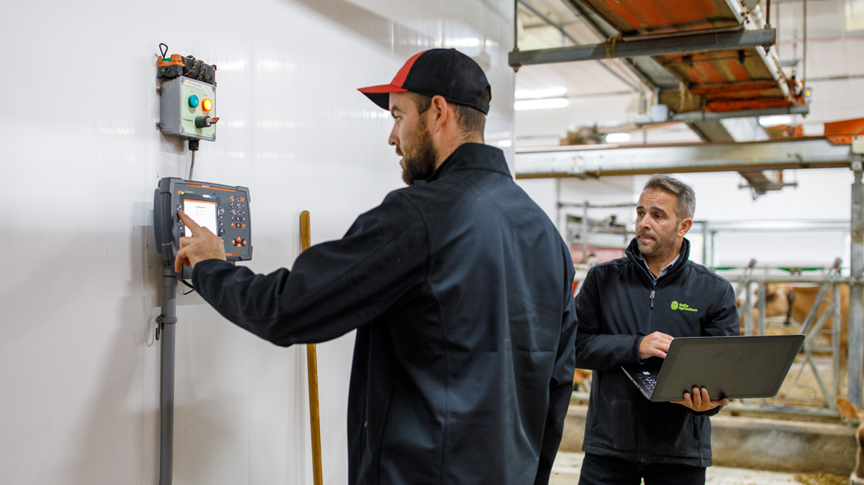 An agri-advisor gives the recommendations of the Lactascan report to the dairy producer who modifies the total mixed ration settings in the automaton.