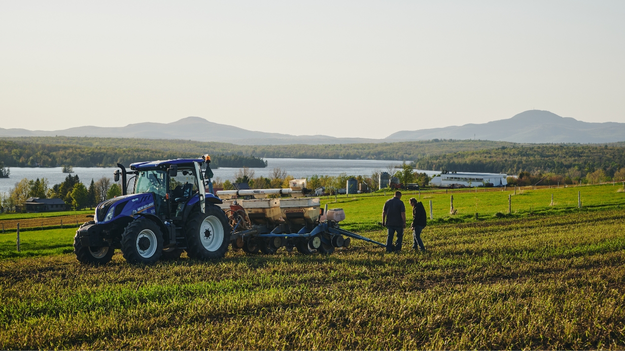 Deux producteurs fertilisent un champ avec un tracteur New Holland.