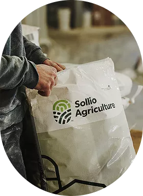 A man opens a bag with the Sollio Agriculture logo on it.