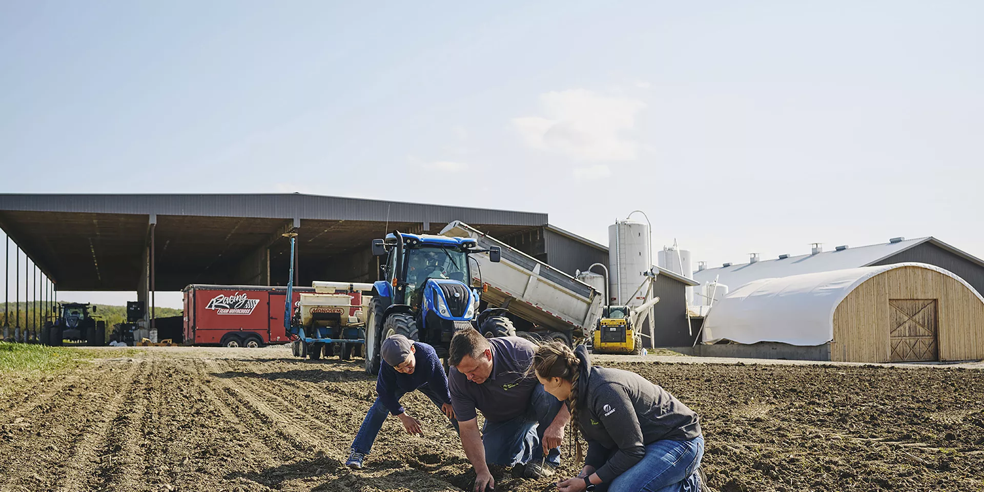 Deux hommes et une femme vérifie le sol agricole.